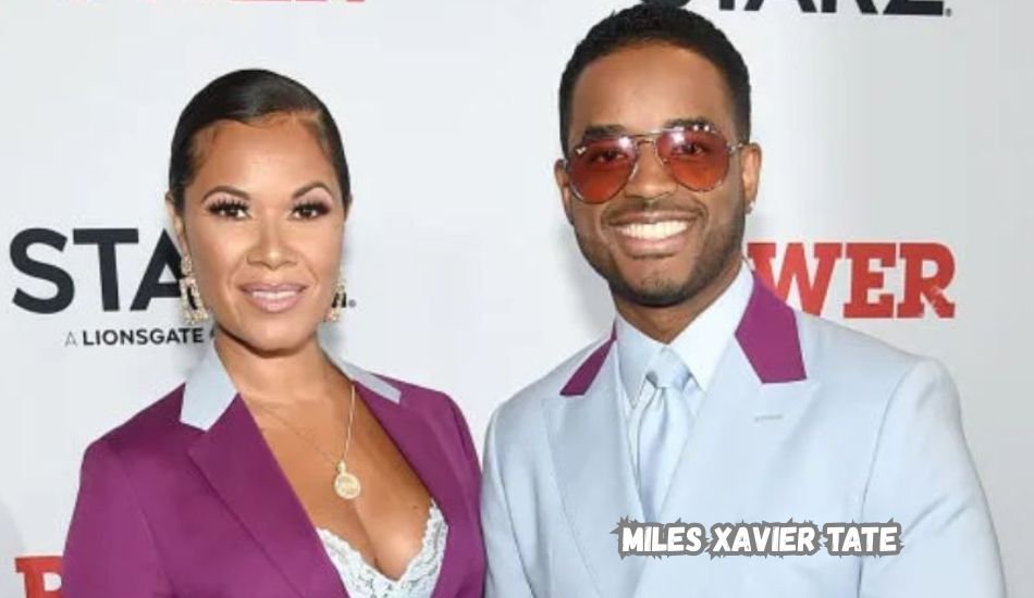 Miles Xavier Tate smiling at a public event in a navy suit