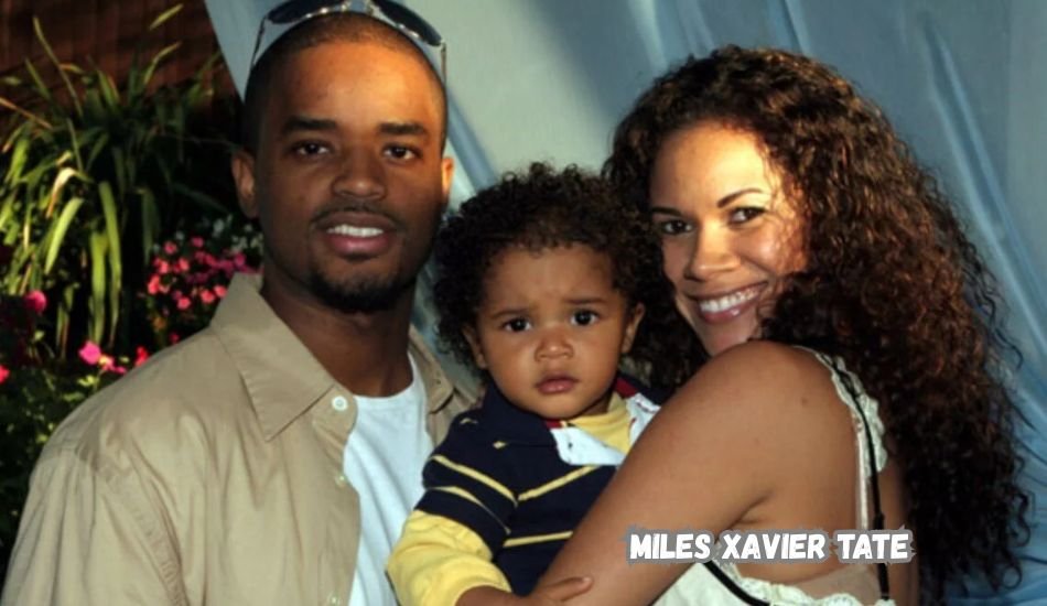 Miles Xavier Tate smiling at a public event in a navy suit