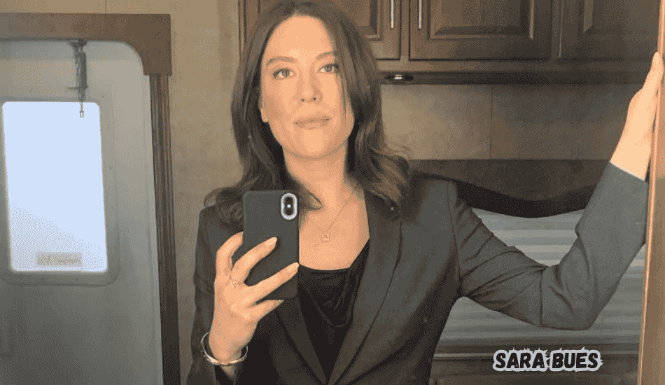 Sara Bues smiling confidently at an event.